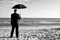 Businessman with umbrella on beach von Sami Sarkis Photography