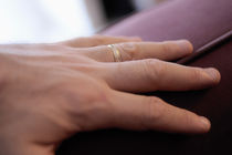 Man's hand on sofa with wedding ring by Sami Sarkis Photography