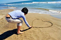 Drawing heartshape in sand by Sami Sarkis Photography