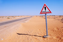 Flood warning sign on desert road by Sami Sarkis Photography