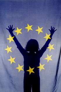Silhouette of girl with arms raised behind European Union Flag by Sami Sarkis Photography