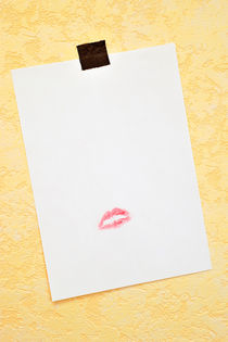 White paper hanged on wall with lipstick kiss von Sami Sarkis Photography