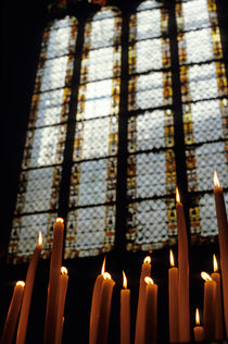 Candles burning in front of a stained glass window in the Auch Cathedral von Sami Sarkis Photography