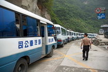 Man searching among a row of tourist buses parked on Mount Hua von Sami Sarkis Photography