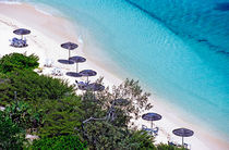 Sun umbrellas dotted along the white sand beach on Amedee Island von Sami Sarkis Photography