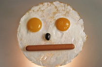 Fried breakfast of eggs and sausage made into a neutral face. by Sami Sarkis Photography
