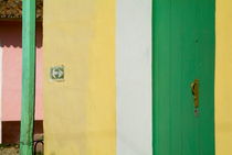 Arrow sign on a building next to a green door on a street in Trinidad von Sami Sarkis Photography