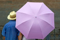 Tourist looking at a wall while sheltering under an umbrella von Sami Sarkis Photography