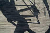 Shadow of a person riding a bicycle. von Sami Sarkis Photography