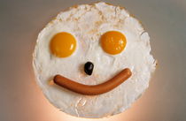 Fried breakfast of eggs and sausage made into a smiling face. von Sami Sarkis Photography