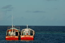 Two red fishing boats moored side by side in the blue ocean von Sami Sarkis Photography