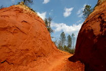 Narrow passage between two bright red sandy cliffs von Sami Sarkis Photography