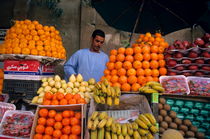 Market vendor selling fruit in a bazaar by Sami Sarkis Photography