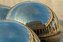 People and buildings reflected on the sphere sculpture within the gardens of the Palais-Royal von Sami Sarkis Photography