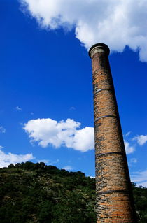 Brick smoke stack emitting smoke von Sami Sarkis Photography