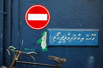 'One Way' street sign above a parked bicycle by Sami Sarkis Photography