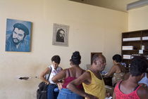 Customers at a pharmacy with Che Guevara portraits on the walls by Sami Sarkis Photography