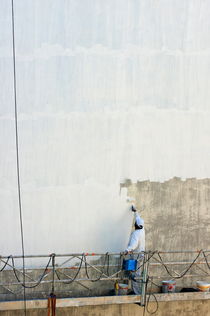 Man painting the facade of a building by Sami Sarkis Photography