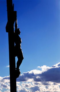 Statue of Jesus Christ on the cross against a cloudy sky. by Sami Sarkis Photography