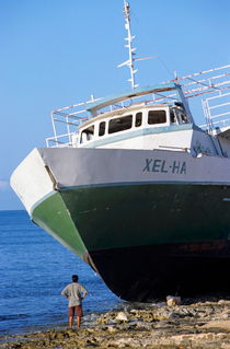 Man looking up at a beached passenger ship on Cozumel Island von Sami Sarkis Photography