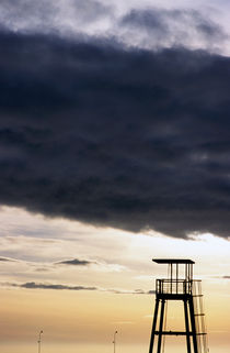 Storm clouds gathering over a lifeguard tower at sunset von Sami Sarkis Photography