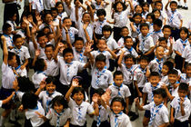 Bangkok school children jumping and smiling at the camera by Sami Sarkis Photography