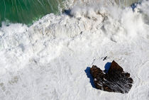 Cormorant flying over heavy waves and rock by Sami Sarkis Photography