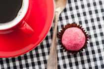 Chocolate truffle and a red coffee cup by Lars Hallstrom